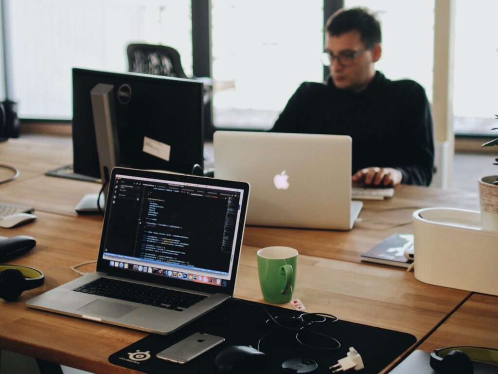 person sat at desk with laptops on using automation to improve workflows